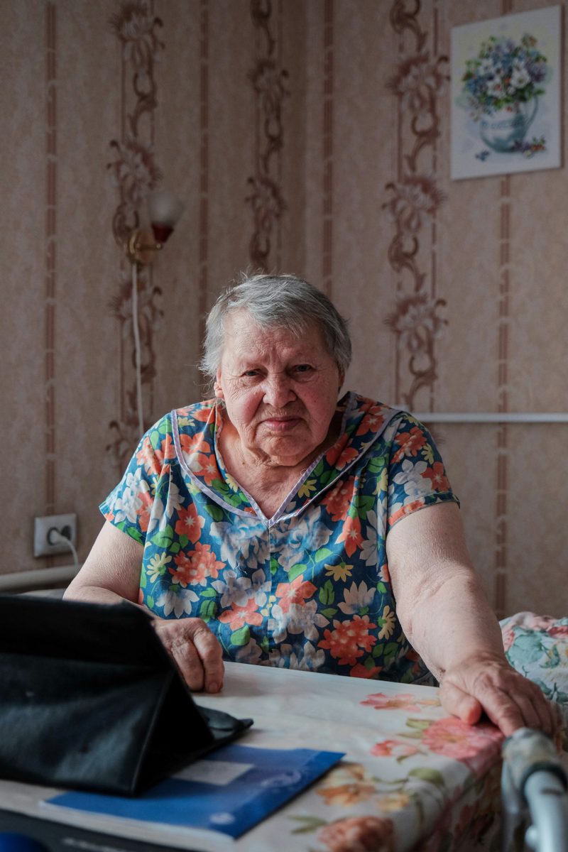 An elderly woman connecting from her kitchen table